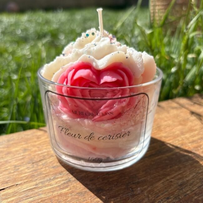 Bougie artisanale parfumée à la fleur de cerisier, avec décoration florale rose et blanche dans un verre MURI