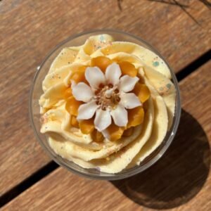 Détail floral sur une bougie parfumée à la pêche vue du dessus de la marque Muri